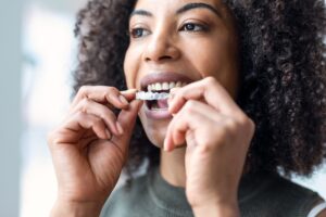 young woman putting in her SureSmile, clear aligner therapy